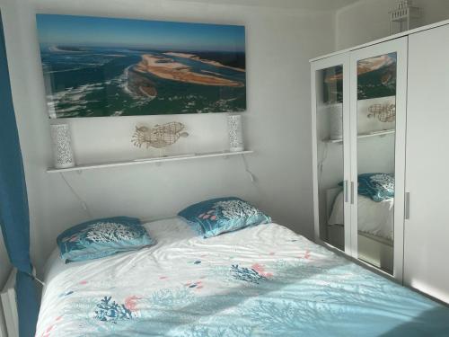 sypialnia z łóżkiem z poduszkami i lustrem w obiekcie T3 FRONT DE MER LACANAU OCEAN - 22m2 TERRASSE -2 PISCINES -WIFI-PARKING w mieście Lacanau-Océan