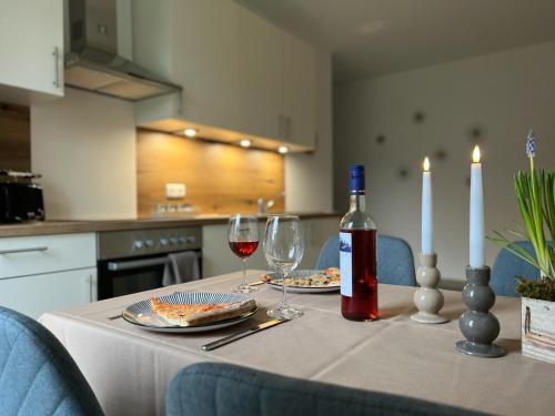 a table with two glasses and a bottle of wine at Ferienwohnung AllerStall in Buchholz Aller
