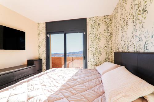 een slaapkamer met een groot bed en een televisie bij Can Camarasa in Cervelló