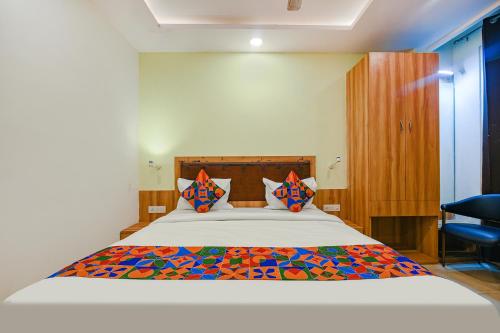 1 dormitorio con 1 cama grande y almohadas coloridas en FabHotel Royal Residency I, en Nueva Delhi