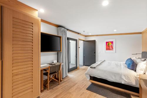 a bedroom with a bed and a desk and a television at SA Carbon Beach Suites in Malibu