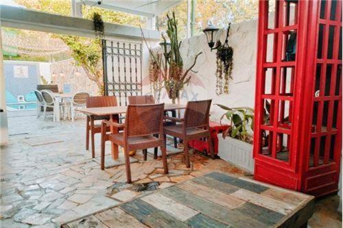 a patio with a table and chairs and a red door at H.younes in El Maamoura