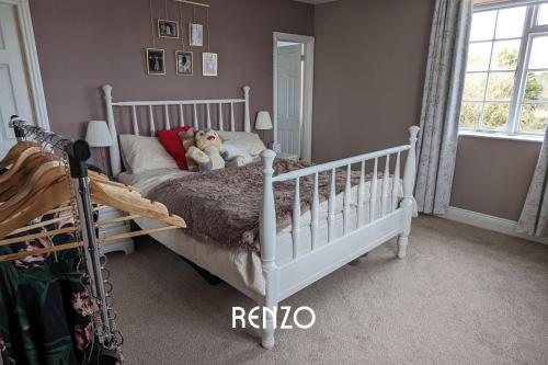 un dormitorio con una cuna blanca con dos animales de peluche en Beautiful 4-bed Home in Nottingham by Renzo, Peaceful Location, Sleeps 8!, en Burton Joyce