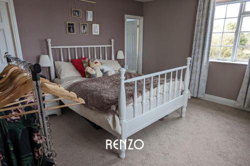 a bedroom with a white crib with two stuffed animals on it at Homely 4-bed Home in Nottingham by Renzo, Peaceful Location, Sleeps 8! in Burton Joyce