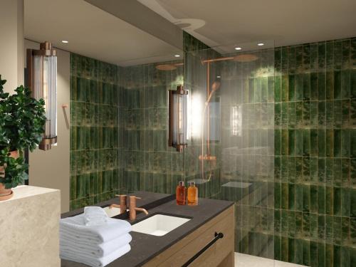 a bathroom with a sink and a shower with green tiles at Henningsvær Bryggehotell - by Classic Norway Hotels in Henningsvær