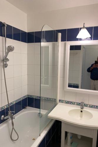 un homme prenant une photo d'une salle de bains dans l'établissement Appartement A22, à Arzon