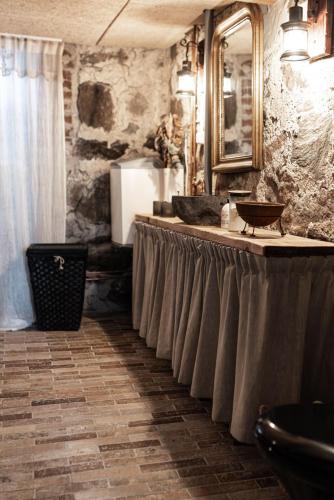 a bathroom with a counter with a sink and a mirror at Östra Nyrups Lantliv in Höör