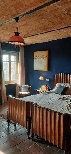 una camera con un grande letto con una parete blu di BIAMICI - casa de vacanze in Mombercelli a Mombercelli