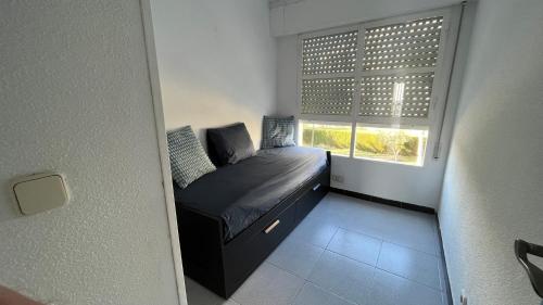 Un dormitorio pequeño con una cama y una ventana. en Apto Cala Real Playa Muchavista - ElCampello, en Alicante