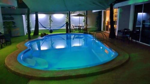 a large blue swimming pool in a house at Coconut Palms in Kantharawichai