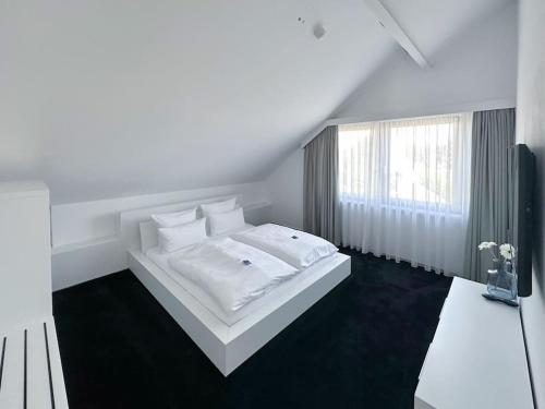 ein weißes Schlafzimmer mit einem weißen Bett und einem Fenster in der Unterkunft ShareBnB in Tobit.Town in Ahaus