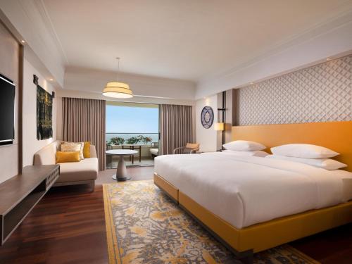 a bedroom with a large bed and a living room at Hilton Bali Resort in Nusa Dua