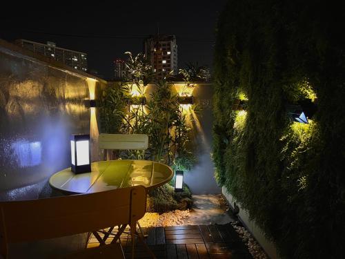 a table and a bench on a patio at night at DOBOY House in Seoul