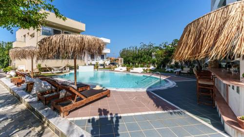 a swimming pool with chairs and umbrellas at Stella Maria in Malia