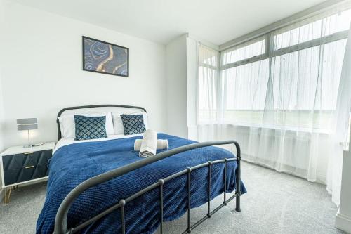 - une chambre avec un lit et une couverture bleue dans l'établissement Bliss: Spacious Beach Home, à Dymchurch
