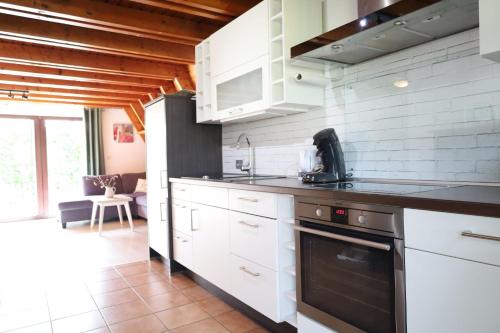 Stickhausen的住宿－Achims Huus 55178，厨房配有白色橱柜和炉灶烤箱。