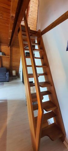 a wooden staircase in a room with a wooden ceiling at Achims Huus 55178 in Stickhausen