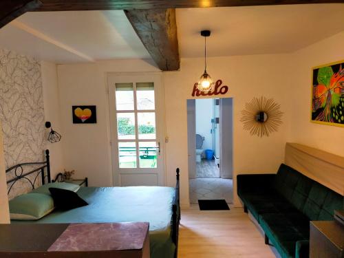 a living room with a bed and a couch at Studio en RDC avec balcon centre Vitré in Vitré