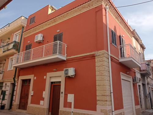 - un bâtiment rouge avec 2 balcons dans une rue dans l'établissement Appartamento L'ANGOLO, à San Severo