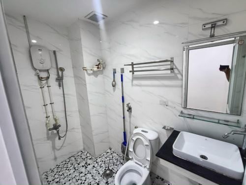 een witte badkamer met een wastafel en een toilet bij Happy House French in Ho Chi Minh-stad