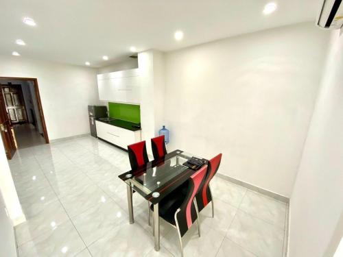 a dining room with a glass table and red chairs at Happy House French in Ho Chi Minh City