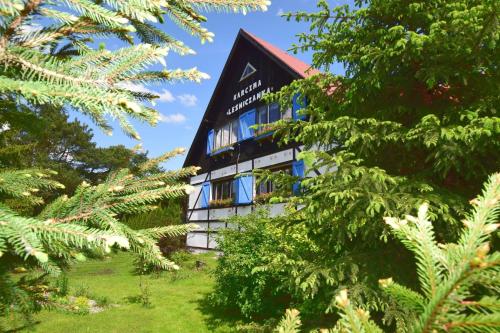 a building with trees in front of it at Karczma Leśniczanka in Wielbark