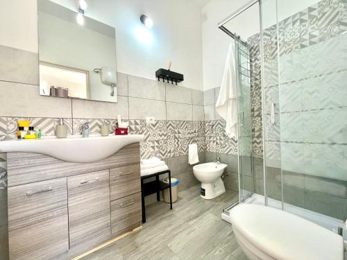 a bathroom with a sink and a toilet and a shower at Bonòra Suites in Tortolì