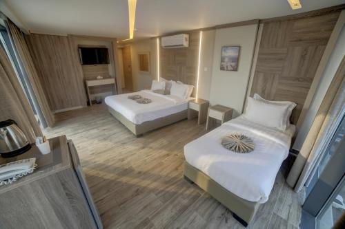 a hotel room with two beds and a desk at Alena Boutique Hotel in Aqaba