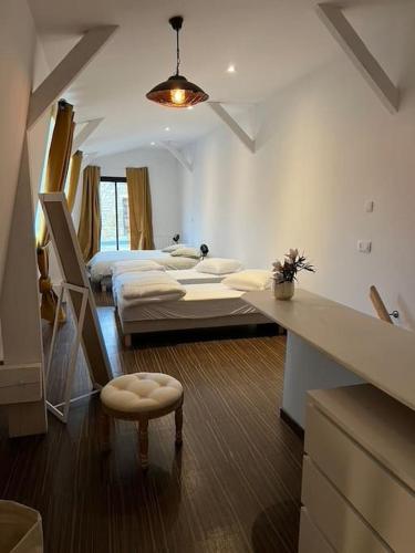 - une chambre avec 2 lits et une table avec un tabouret dans l'établissement Grand duplex de 80m2, à Aleçon
