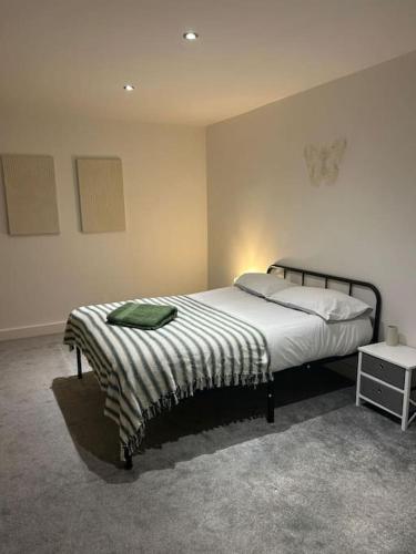 - une chambre avec un lit et une couverture rayée dans l'établissement Luxurious 3-Bed Penthouse, à Handsworth