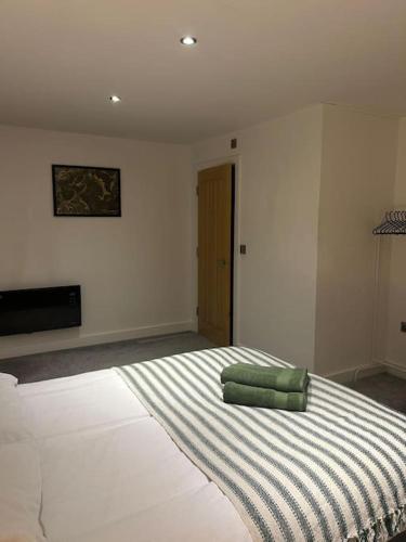 Habitación blanca con cama con almohadas verdes. en Luxurious 3-Bed Penthouse en Handsworth