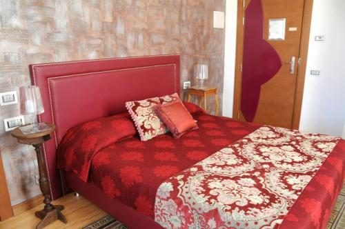 a bedroom with a red bed with pillows on it at Residenza Mordini in La Maddalena