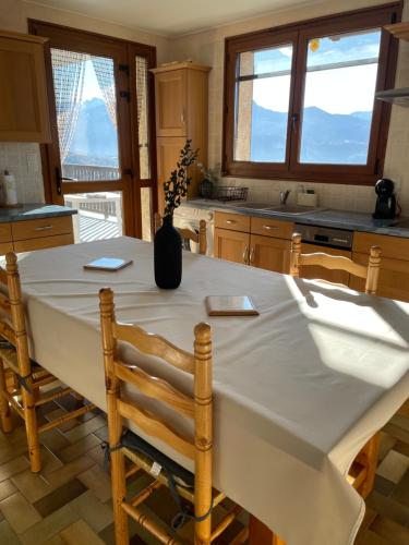 a kitchen with a table with a vase on it at Appartement T3 avec vue sur le lac in Chorges