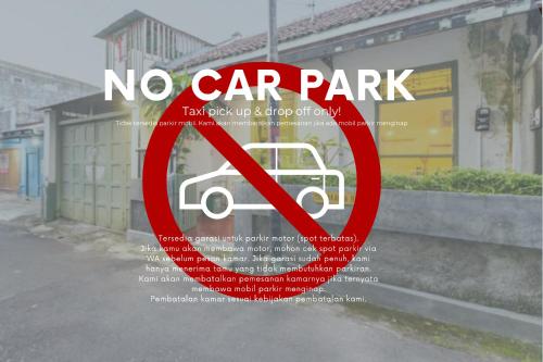 um sinal de não estacionamento com uma fotografia de um carro estacionado em Yogyakarta BnB Malioboro em Yogyakarta
