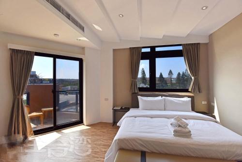 馬公市的住宿－海洋景觀會館民宿 ，一间卧室设有一张大床和一个大窗户