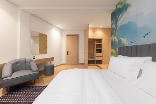 una camera da letto con un letto grande e una sedia di Tree House Boutique Hotel ad Abuja