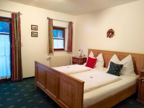 - une chambre avec un lit en bois et des oreillers dans l'établissement Jagersimmerl, à Grünau im Almtal