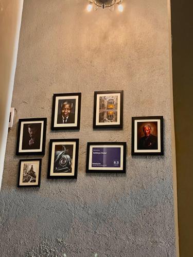 a group of framed photos on a wall at Ashleys Hotel in Kampala