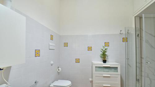 a white bathroom with a toilet and a shower at VILLA AFRODITE 8, Emma Villas in Milazzo