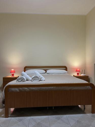 um quarto com uma cama com dois candeeiros em duas mesas em Appartamento A due passi dal mare em Caulonia Marina