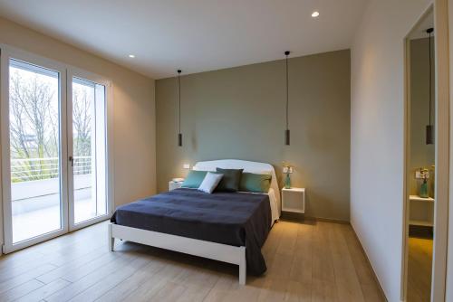 Un dormitorio con una cama y una ventana grande. en Green Apartments a Igea Marina - jungle, en Bellaria-Igea Marina