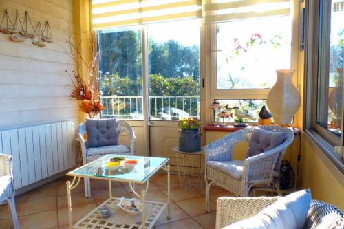 une chambre avec des chaises, une table et des fenêtres dans l'établissement Nice house with private pool, à Sanary-sur-Mer