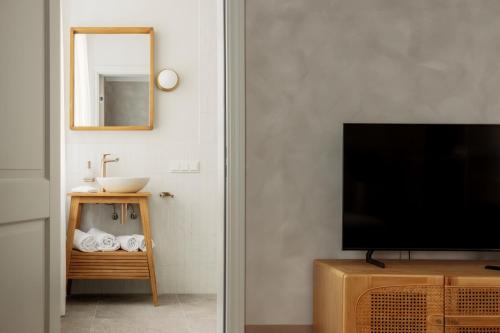 a living room with a television and a sink at Spīdalas nams in Cēsis