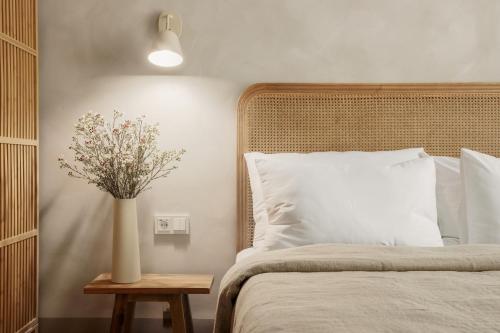 a bedroom with a bed with a vase of flowers on a table at Spīdalas nams in Cēsis