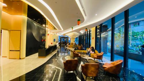 um lobby de um hotel com pessoas sentadas em cadeiras em Axon suites by GALAXY HOUSE em Kuala Lumpur
