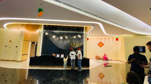 Axon suites by GALAXY HOUSE في كوالالمبور: شخصين واقفين أمام متجر akoya