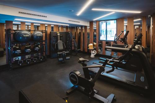 a gym with several treadmills and machines in it at Hotel Pinar Plaza in Madrid