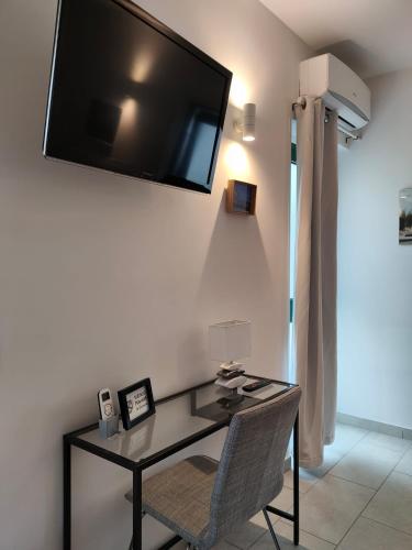 a desk with a television on a wall with a chair at L'ANFORA DELLE MURELLE in Torre di Montalto