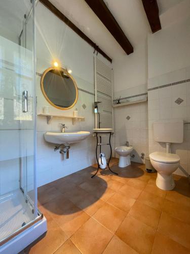 Alloggio Sole في Faedis: حمام مع حوض ومرحاض ومرآة