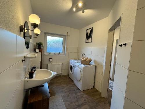 a bathroom with a sink and a washing machine at Ferienhaus Tamko 95161 in Rhauderfehn